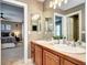 Bright bathroom with a double sink vanity, neutral paint, and adjoined to a bedroom at 580 Crossing Cir, Castle Pines, CO 80108