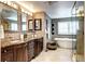 Beautiful bathroom with dual sinks, granite countertops, and a soaking tub with mosaic tile accents at 580 Crossing Cir, Castle Pines, CO 80108