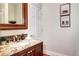 Stylish bathroom vanity with granite countertop, mosaic tile backsplash, and decorative mirror at 580 Crossing Cir, Castle Pines, CO 80108