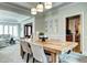 Charming dining room with natural wood table, tray ceiling, and open layout to the kitchen and living spaces at 580 Crossing Cir, Castle Pines, CO 80108