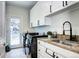 Well-lit laundry room with modern washer and dryer, granite countertops, and ample storage at 580 Crossing Cir, Castle Pines, CO 80108