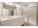 Bathroom featuring double sink vanity, quartz countertop, and glass enclosed shower at 18336 Prince Hill Cir, Parker, CO 80134