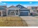 Attractive blue home featuring a well-kept lawn, stone details, and a two-car garage at 18336 Prince Hill Cir, Parker, CO 80134