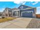 Inviting blue home with two-car garage, stone accents, and spacious driveway at 18336 Prince Hill Cir, Parker, CO 80134