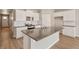 Modern kitchen features white cabinets, island with sink, stainless steel appliances, and wood-look floors at 18336 Prince Hill Cir, Parker, CO 80134
