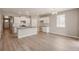 Bright living room with open kitchen, white cabinets, wood floors, and modern lighting at 18336 Prince Hill Cir, Parker, CO 80134
