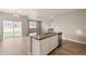 Open concept living space with wood-look floors, kitchen island, and sliding glass doors to the yard at 18336 Prince Hill Cir, Parker, CO 80134