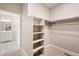 A well-lit walk-in closet featuring built-in shelving for storage at 18336 Prince Hill Cir, Parker, CO 80134