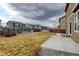 Grassy backyard with a wooden fence, stone landscaping and a view of other homes at 5686 Eagle River Pl, Brighton, CO 80601