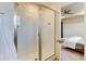 Modern bathroom featuring a glass-enclosed shower and a glimpse of the bedroom at 5686 Eagle River Pl, Brighton, CO 80601