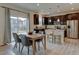 Bright dining area with hardwood floors, modern table, gray chairs, and view of the kitchen and sliding doors to backyard at 5686 Eagle River Pl, Brighton, CO 80601