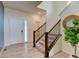 Bright entryway features hardwood floors and a staircase with wrought iron spindles, leading to the upper level of the home at 5686 Eagle River Pl, Brighton, CO 80601