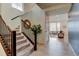 Inviting foyer with hardwood floors, staircase with wrought iron spindles, and a view into the bright and open living space at 5686 Eagle River Pl, Brighton, CO 80601