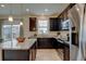 Modern kitchen with dark cabinets, granite countertops, stainless steel appliances, and a center island with bar seating at 5686 Eagle River Pl, Brighton, CO 80601