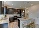 Modern kitchen with dark cabinets, granite countertops, stainless steel appliances, and a center island with bar seating at 5686 Eagle River Pl, Brighton, CO 80601