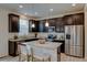 Modern kitchen with dark cabinets, granite countertops, stainless steel appliances, and a center island with bar seating at 5686 Eagle River Pl, Brighton, CO 80601