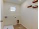 A dedicated laundry room with hook and shelf accents, a convenient utility sink, and clean finishes at 5686 Eagle River Pl, Brighton, CO 80601