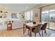 Open-concept living and dining area featuring hardwood floors, neutral color palette, and sliding glass doors to the backyard at 5686 Eagle River Pl, Brighton, CO 80601