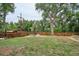 Large, grassy backyard featuring a fire pit, mature trees, and a wood fence at 6055 E Minnesota Dr, Denver, CO 80224