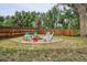Cozy backyard fire pit area with colorful chairs and a charming stone surround at 6055 E Minnesota Dr, Denver, CO 80224