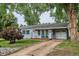 Charming single-story home with a cozy front porch and a well-maintained yard shaded by mature trees at 6055 E Minnesota Dr, Denver, CO 80224