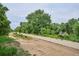 Picturesque walking path through natural greenery, shaded by mature trees at 6055 E Minnesota Dr, Denver, CO 80224