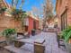 Backyard brick patio with an outdoor kitchen, featuring seating, mature trees, and elegant landscaping at 106 S University Blvd # 2, Denver, CO 80209