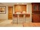 Basement bar featuring wooden cabinets, leather chairs with metal legs, and a wooden countertop at 106 S University Blvd # 2, Denver, CO 80209