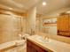 Traditional bathroom with a beige tile floor, wooden cabinets, and a shower featuring glass doors at 106 S University Blvd # 2, Denver, CO 80209