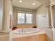Elegant soaking tub set in marble, framed by decorative columns, and adorned with a stained glass window at 106 S University Blvd # 2, Denver, CO 80209