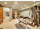 Basement fitness area including exercise equipment, carpeted flooring, and wooden door at 106 S University Blvd # 2, Denver, CO 80209