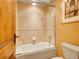 Shower tub combination with glass sliding doors and neutral ceramic tile surround with a toilet and artwork visible at 106 S University Blvd # 2, Denver, CO 80209