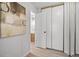 Hallway view with closet leading into bathroom, featuring neutral wall art and laminate flooring at 6755 S Field St # 625, Littleton, CO 80128