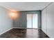 Bedroom featuring dark hardwood flooring, neutral walls, a modern light fixture, and a glass sliding door at 1128 S Ventura Cir # K, Aurora, CO 80017