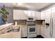 Bright kitchen featuring white cabinets, modern appliances, and a breakfast bar at 1128 S Ventura Cir # K, Aurora, CO 80017
