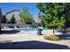 Community pool with a deck, lounge chairs, and clear blue water, surrounded by mature trees at 1128 S Ventura Cir # K, Aurora, CO 80017