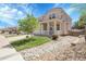 Two-story home with a porch, surrounded by well-maintained landscaping, stones, and a healthy green lawn at 2354 Cactus Bloom Ct, Castle Rock, CO 80109
