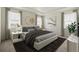 This staged bedroom features neutral tones, large windows, contemporary decor, and is bathed in natural light at 1884 Sawtooth Mountain Dr, Berthoud, CO 80513
