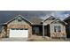 Charming home showcasing a brick and siding exterior, complemented by a pristine white garage door and inviting entryway at 1884 Sawtooth Mountain Dr, Berthoud, CO 80513
