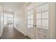 Bright hallway with wood floors and glass French doors leading to another room, enhancing the home's appeal at 1884 Sawtooth Mountain Dr, Berthoud, CO 80513