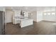 This kitchen features white cabinets, stainless steel appliances, and an adjacent living space at 1884 Sawtooth Mountain Dr, Berthoud, CO 80513