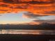 Scenic lake view with the mountains in the background with a breathtaking orange and yellow colored sunset at 1884 Sawtooth Mountain Dr, Berthoud, CO 80513