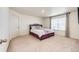 Bright bedroom with a queen-sized bed, soft carpet, and a window with blinds at 129 S Waterloo St, Aurora, CO 80018