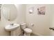 Cozy powder room with a pedestal sink, neutral walls, and stylish decor at 129 S Waterloo St, Aurora, CO 80018