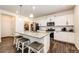 Bright kitchen featuring stainless steel appliances, granite countertops, island with stools, and a pantry at 129 S Waterloo St, Aurora, CO 80018