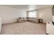 Cozy living room with neutral carpet, comfortable L-shaped sofa, and window at 129 S Waterloo St, Aurora, CO 80018