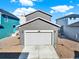Exterior view of a two-car garage, with a well-maintained driveway and neutral siding complementing the surrounding landscape at 470 Kiowa Ave, Bennett, CO 80102
