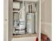 Utility closet featuring a furnace and water heater for essential home systems at 470 Kiowa Ave, Bennett, CO 80102