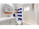 Bright bathroom features a shower and tub combo with blue-striped curtain and decorative orange shelves at 602 5Th St, Golden, CO 80403
