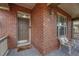 Close up of the brick front porch with a welcome mat, chair, and exterior lighting at 3434 Fantasy Pl, Castle Rock, CO 80109